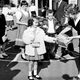 Kids await, standing on numbers, while one girl picks the winner.